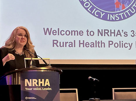 Carole Johnson speaks from a podium at the NRHA Policy Institute