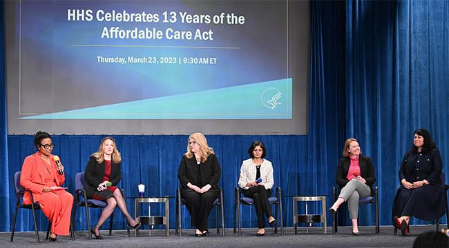 HRSA Administrator Carole Johnson is seated on stage with several other HHS leaders at an event marking 13th anniversary of the Affordable Care Act. 