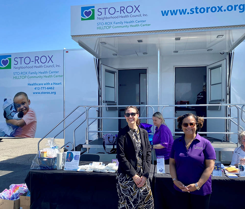 HRSA Region 3 Regional Administrator Leah Suter stands with staff of the Sto-Rox Neighborhood Health Council in front of their display table. 