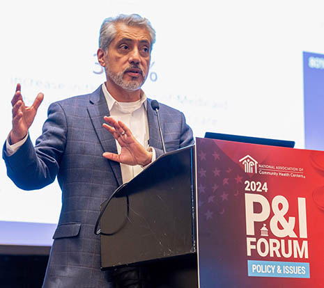 BHW Associate Administrator Dr. Luis Padilla speaks from a podium at the 2024 P&I Forum