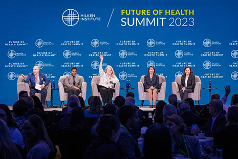 Attendees seated on stage at 2023 Milken Institute Future of Health Summit. HRSA Administrator Carole Johnson is raising her hand.