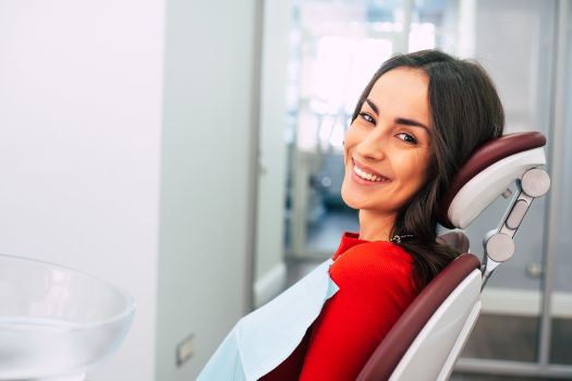 A smiling woman sitting in a dental exam chair.