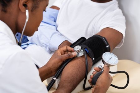  A health care professional measuring a patient’s blood pressure.