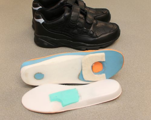 A molded modified orthotic and shoes.
