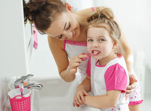 A small child is getting it's teeth cleaned with a toothbrush.