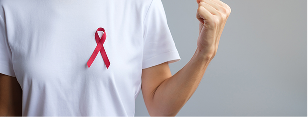 A person is standing in a white t-shirt with a red ribbon on it.